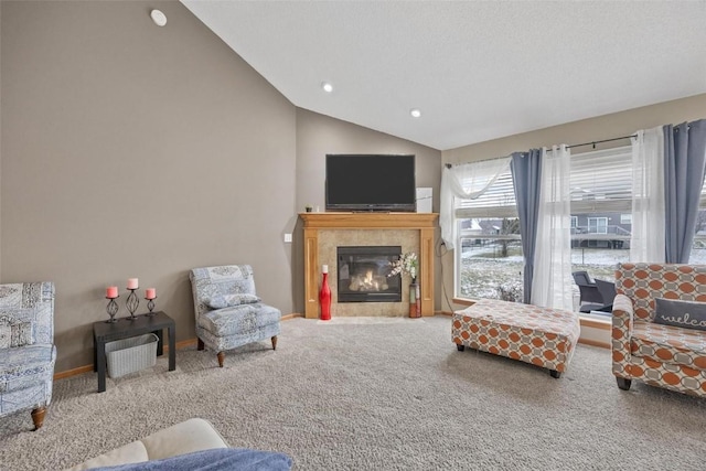 carpeted living room with a tile fireplace and lofted ceiling