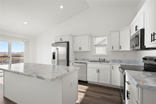 kitchen featuring a center island, light stone counters, white cabinetry, and appliances with stainless steel finishes