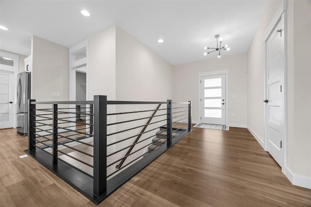 foyer with hardwood / wood-style flooring and a notable chandelier