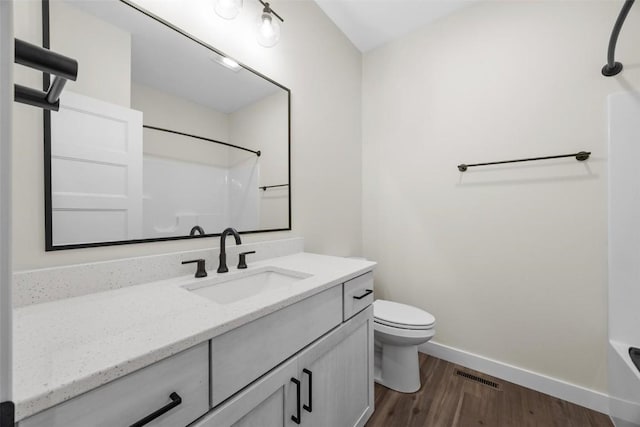 full bathroom with hardwood / wood-style floors, vanity, toilet, and shower / bath combination