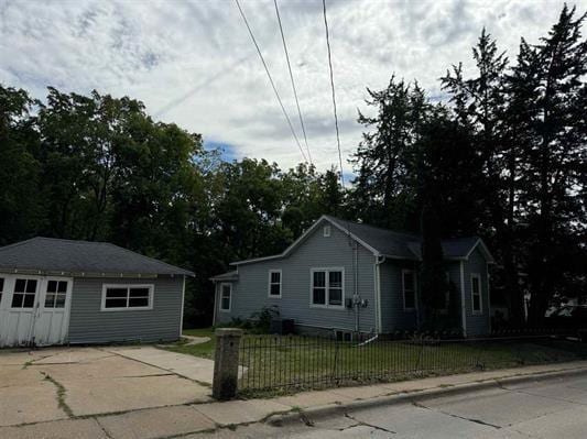 view of front of home with an outdoor structure and a front lawn