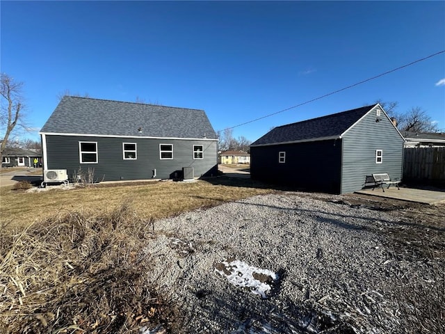 back of house featuring ac unit and an outdoor structure