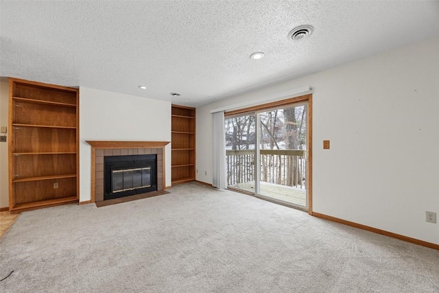 unfurnished living room featuring a textured ceiling, a fireplace, and light carpet