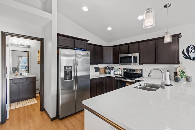 kitchen featuring pendant lighting, sink, light wood-type flooring, appliances with stainless steel finishes, and dark brown cabinets