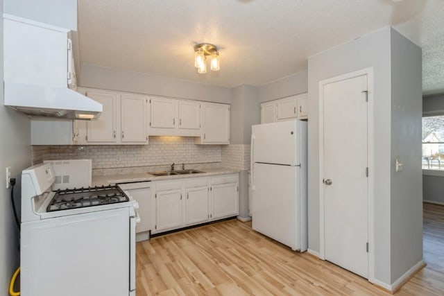 kitchen featuring decorative backsplash, white appliances, ventilation hood, sink, and white cabinets