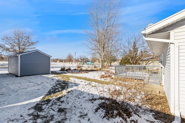 yard layered in snow with a storage unit