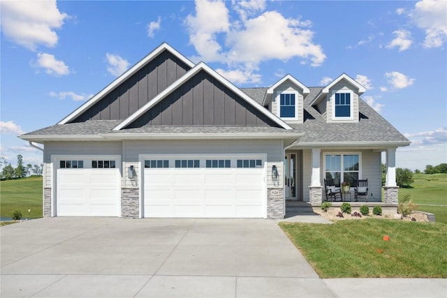 craftsman-style home with a porch, a garage, and a front yard