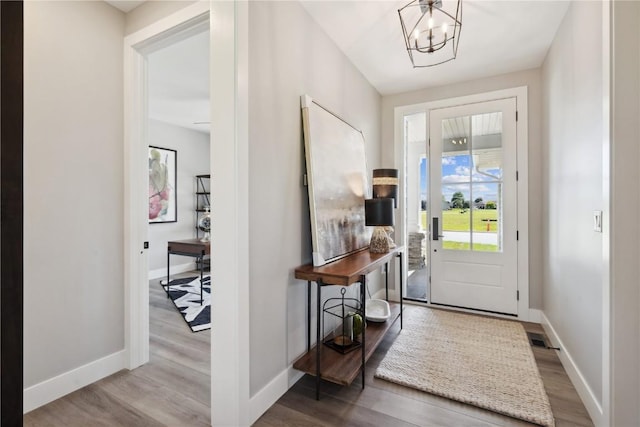 entrance foyer with hardwood / wood-style floors and an inviting chandelier