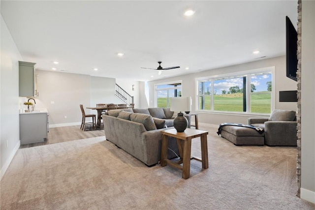 living room with ceiling fan and light hardwood / wood-style floors