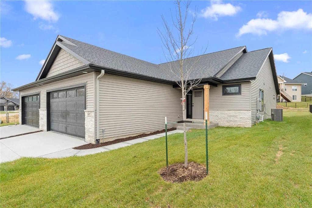 ranch-style home featuring a front lawn, a garage, and central AC