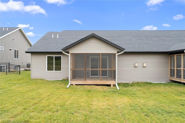 back of property with central AC unit, a lawn, and a sunroom