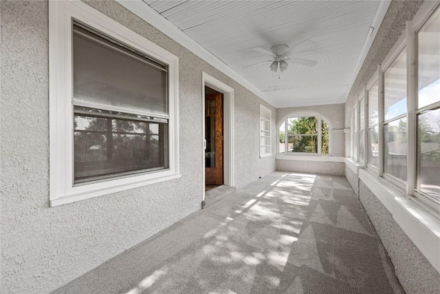 unfurnished sunroom with ceiling fan