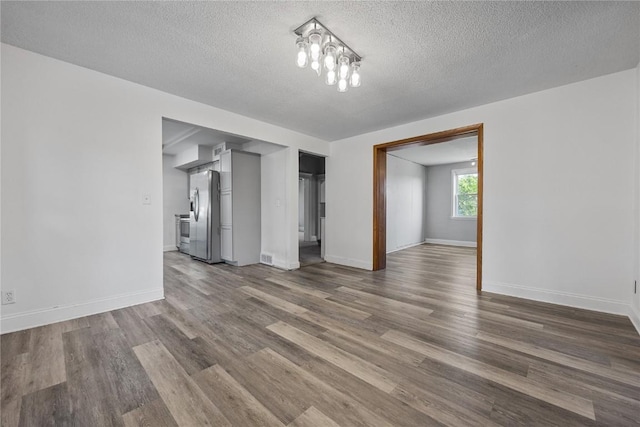 unfurnished living room featuring a textured ceiling and hardwood / wood-style floors