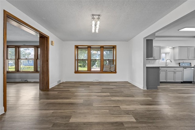 unfurnished dining area with sink, a textured ceiling, and dark hardwood / wood-style flooring