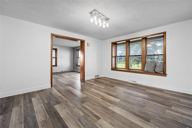 spare room with dark wood-type flooring and a textured ceiling