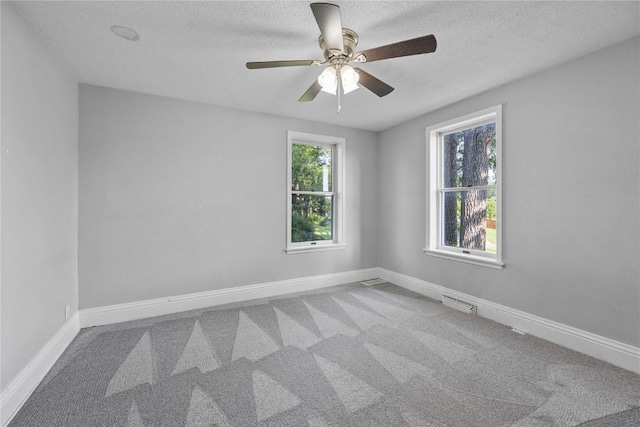 spare room featuring carpet floors, ceiling fan, and a textured ceiling