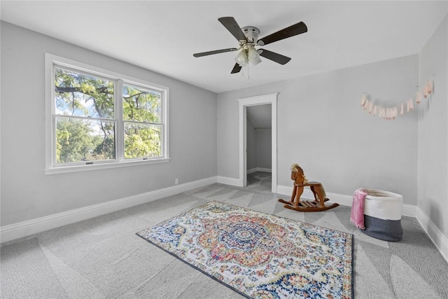 carpeted bedroom with ceiling fan, a walk in closet, and a closet