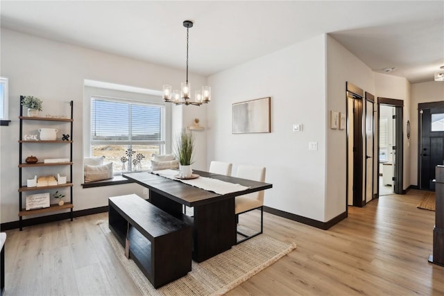 dining area with a notable chandelier and light hardwood / wood-style flooring