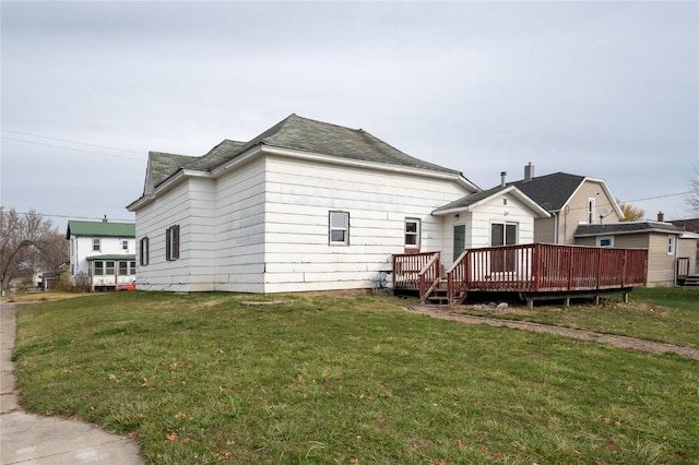 rear view of house with a lawn and a wooden deck