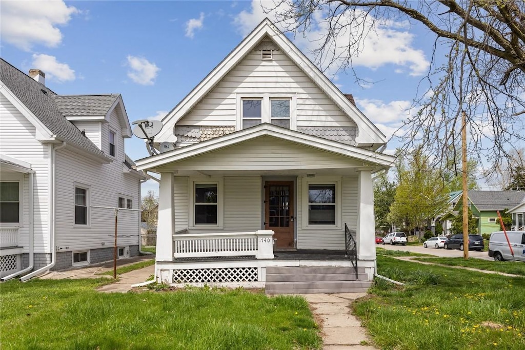 bungalow-style house featuring a porch and a front lawn