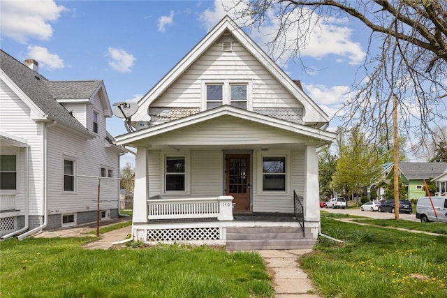 bungalow-style house featuring a porch and a front lawn