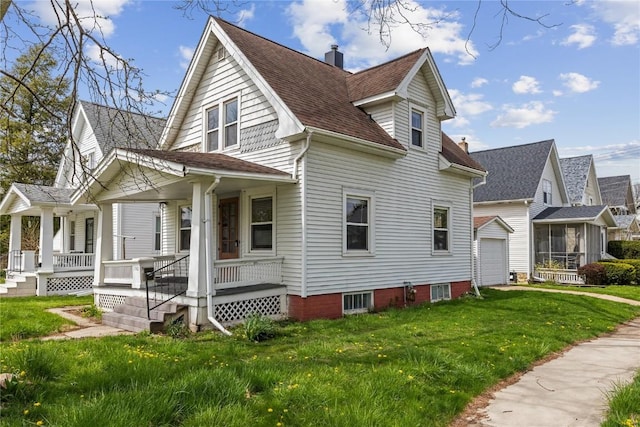 exterior space featuring a lawn, an outbuilding, a garage, and a porch