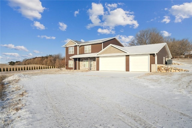 view of front facade featuring central AC and a garage