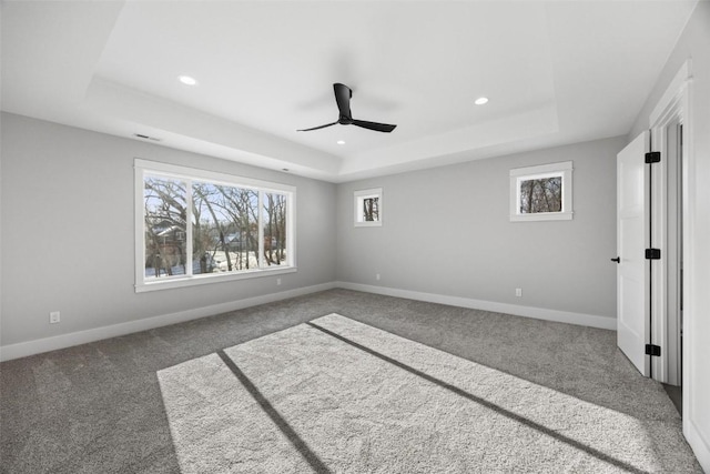 unfurnished bedroom featuring carpet floors, ceiling fan, and a tray ceiling