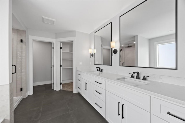 bathroom featuring vanity, tile patterned flooring, and a shower with shower door