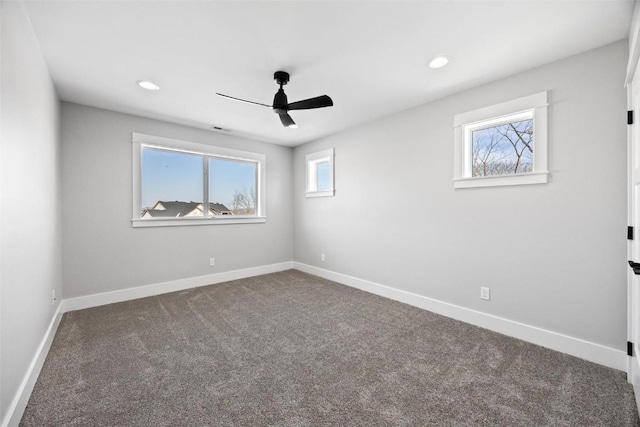 carpeted spare room featuring ceiling fan