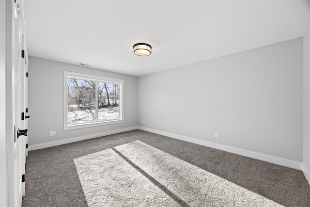 unfurnished room featuring dark carpet