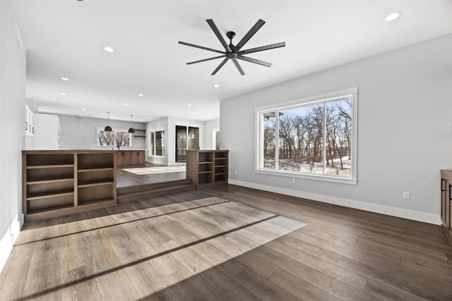 unfurnished living room with ceiling fan and hardwood / wood-style flooring