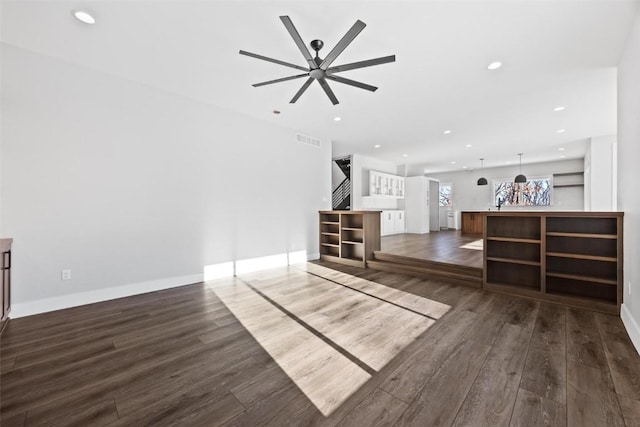 unfurnished living room featuring ceiling fan and dark hardwood / wood-style floors