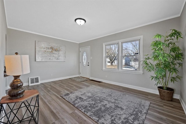 entryway with ornamental molding and wood-type flooring