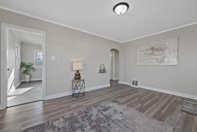 empty room with crown molding and hardwood / wood-style floors