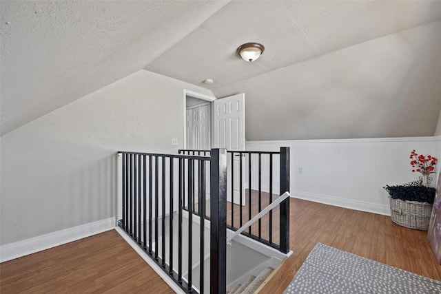 bonus room featuring vaulted ceiling, a textured ceiling, and hardwood / wood-style flooring