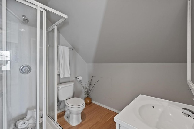 bathroom featuring lofted ceiling, toilet, wood-type flooring, a shower with door, and vanity