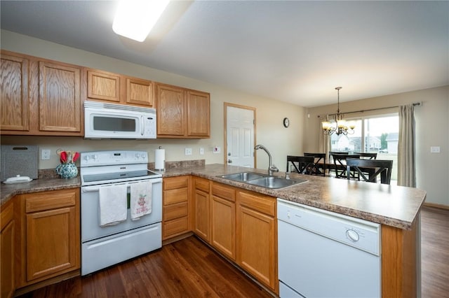 kitchen with white appliances, hanging light fixtures, kitchen peninsula, sink, and an inviting chandelier