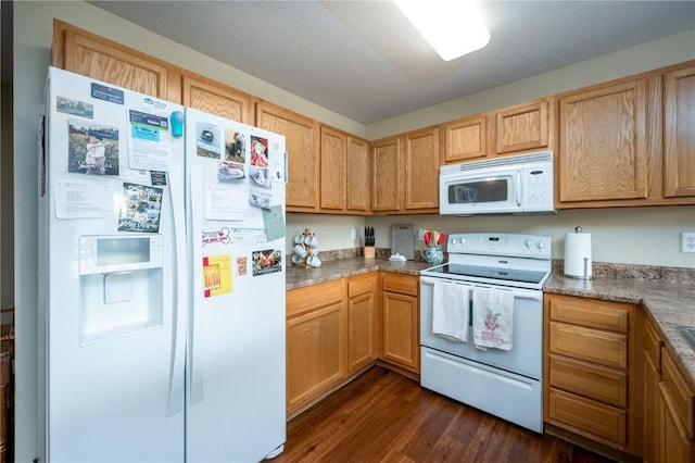 kitchen featuring white appliances and dark hardwood / wood-style flooring