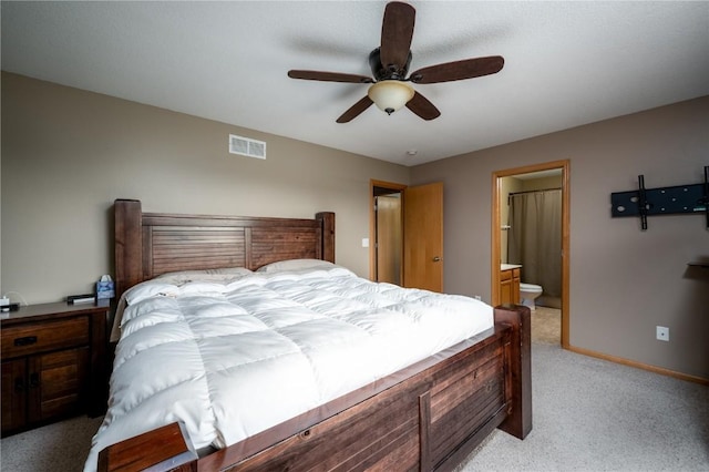 bedroom featuring ceiling fan, ensuite bathroom, and light carpet