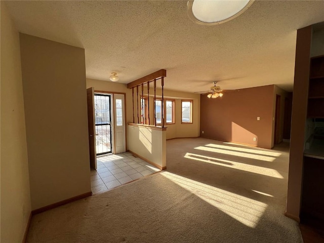 unfurnished living room featuring ceiling fan, light carpet, and a textured ceiling