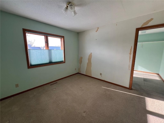 spare room with a textured ceiling and carpet flooring