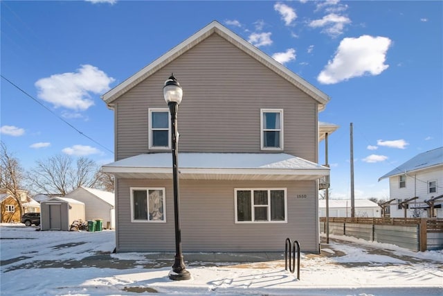 snow covered property featuring a storage unit