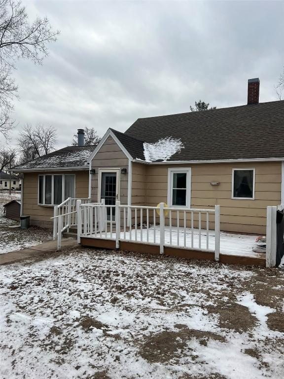 snow covered house featuring a wooden deck