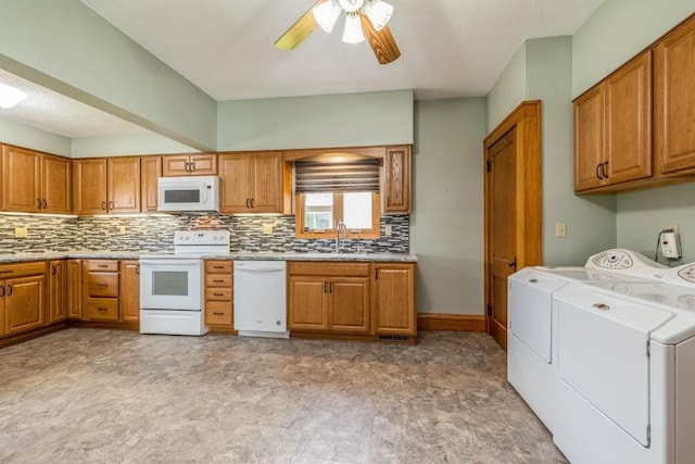 kitchen with sink, white appliances, ceiling fan, washer and clothes dryer, and backsplash