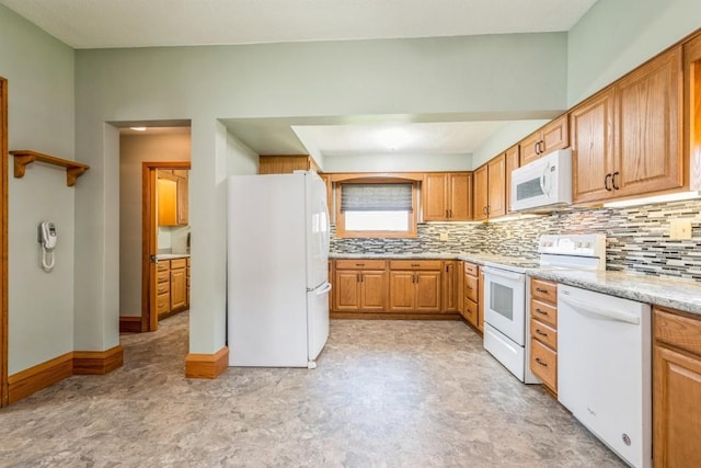 kitchen with white appliances, decorative backsplash, and light stone countertops