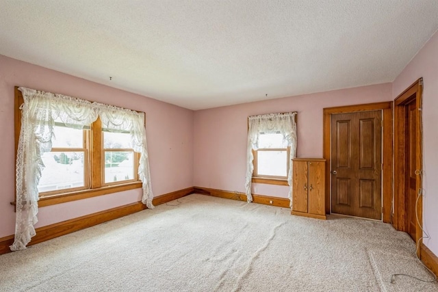 spare room featuring a textured ceiling and carpet floors