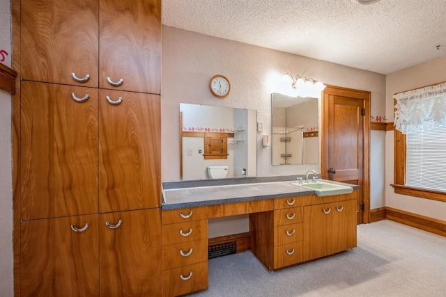 bathroom with toilet, a textured ceiling, and vanity