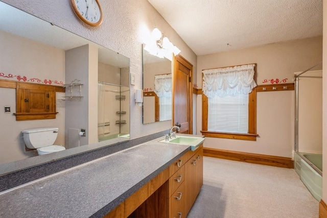 full bathroom with a textured ceiling, bath / shower combo with glass door, vanity, and toilet