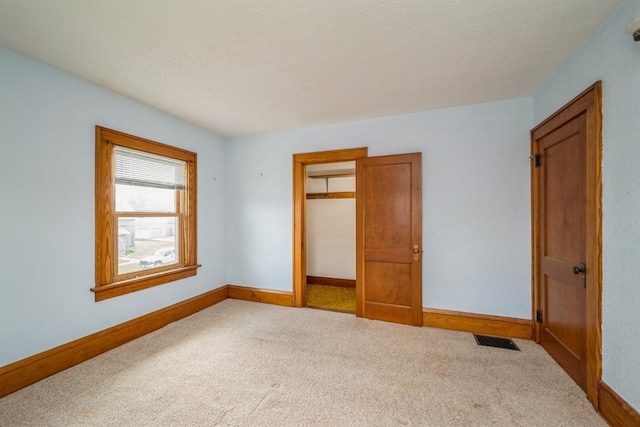 unfurnished bedroom with a closet and light carpet